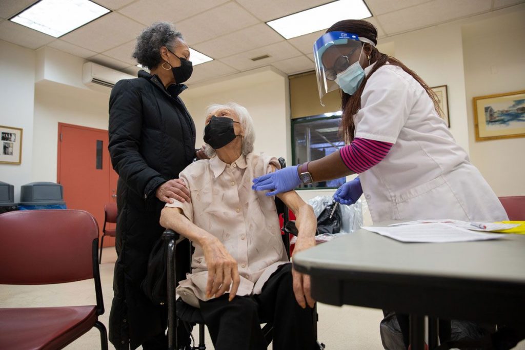 doctor giving injection to an old woman at YM&YA