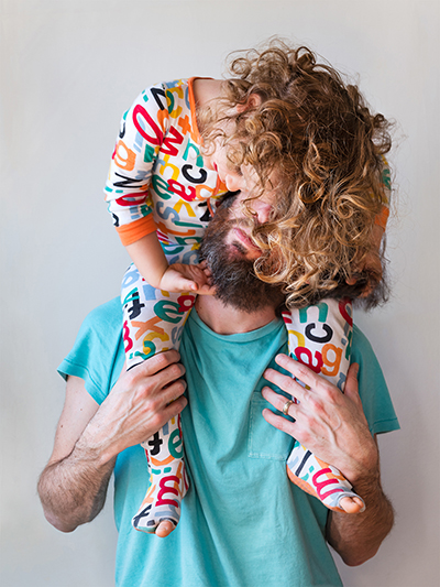 kid sitting on fathers shoulders showing affection at YM&JA