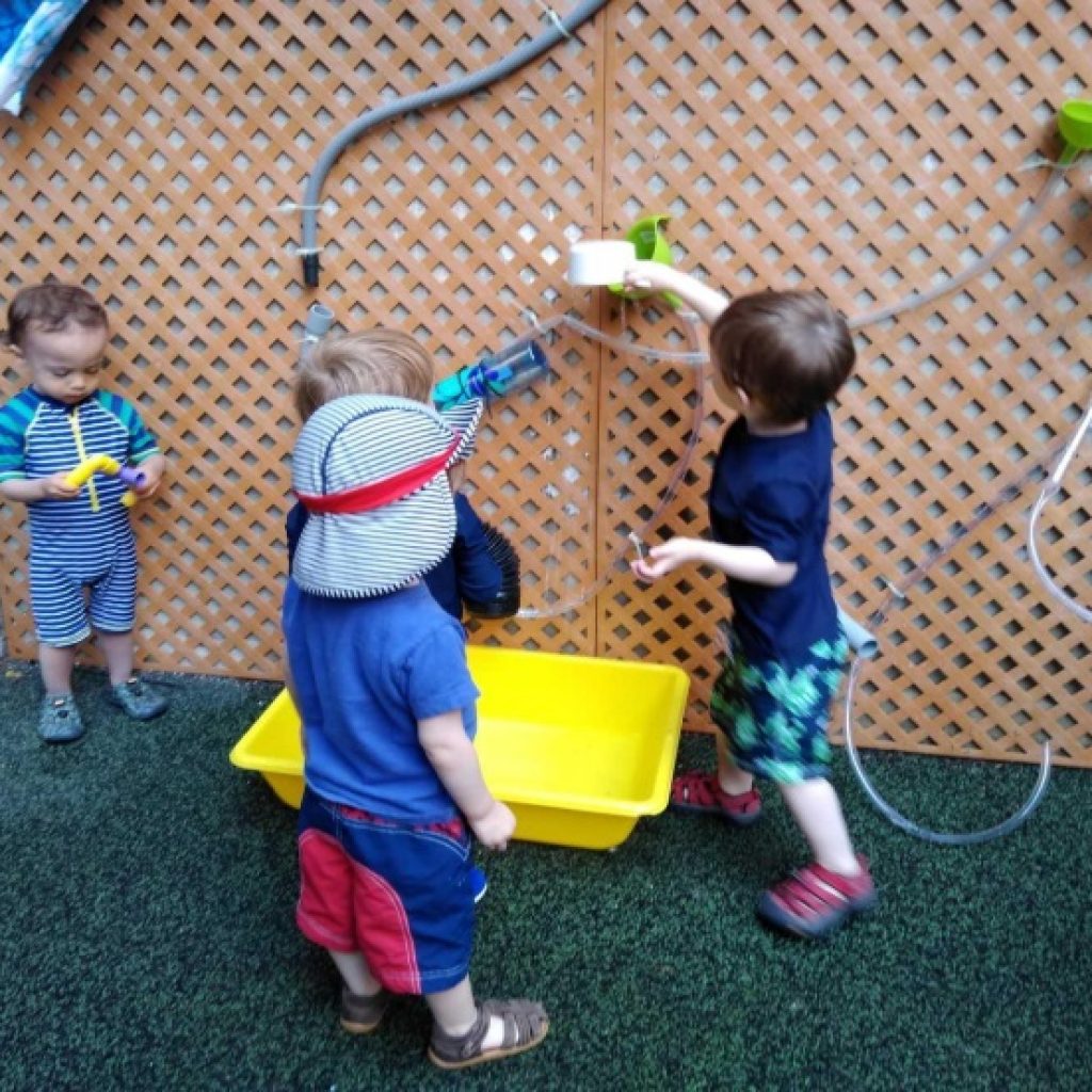 kids playing with decorative water wall at YM&हाँ